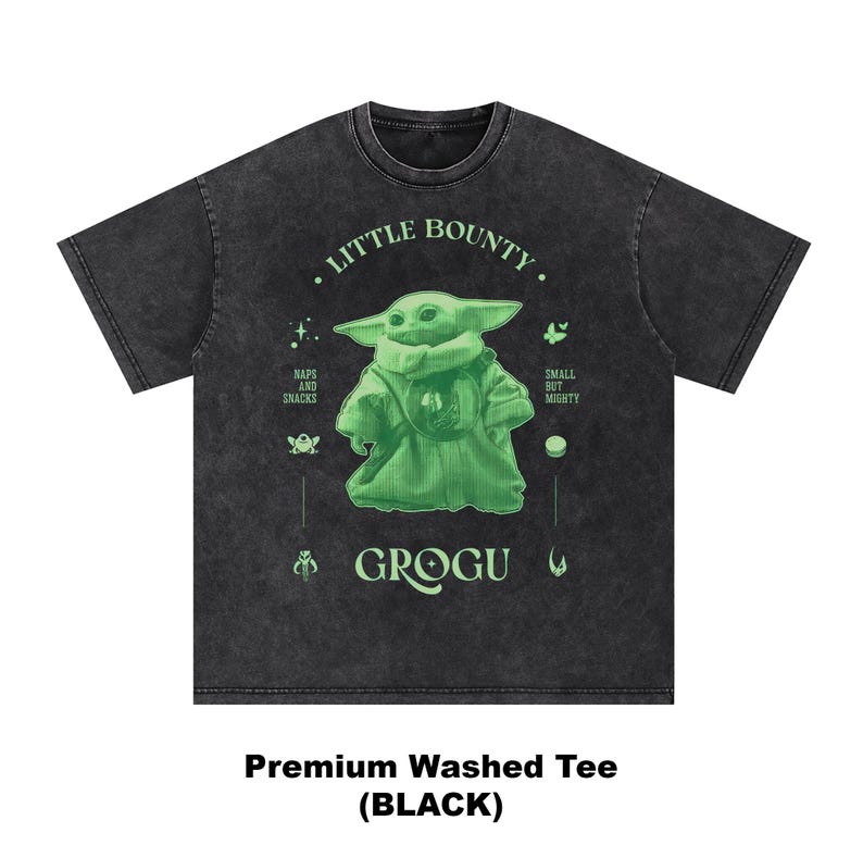 Op de afbeelding: Zwart premium gewassen T-shirt met een groene Grogu-afbeelding en de tekst "Little Bounty". Het ontwerp bevat de zinnen "Naps and Snacks" en "Small but Mighty". Het shirt heeft een donkergrijze kleur.