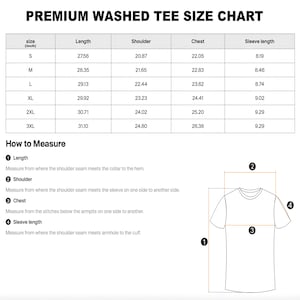 Op de afbeelding: Een witte maattabel voor premium gewassen T-shirts, met afmetingen in inches voor maten S tot 3XL. Inclusief lengte, schouder, borst en mouwlengte. Toont ook hoe je elk deel van het shirt meet.