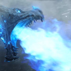 Könnte beinhalten: Nahaufnahme eines Drachenkopfes, der einen Strahl hellblauer Flammen ausstößt. Der Drache ist grau mit scharfen Zähnen und leuchtend blauen Augen. Der Hintergrund ist ein stürmischer, bedeckter Himmel mit Schnee.