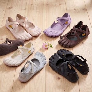 May include: A collection of Vibram five-finger shoes in various colours including light pink, lavender, dark brown, white, grey, and black, arranged in a circle around a single small pink flower. Each shoe features individual toe slots.