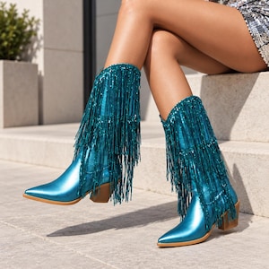 May include: A pair of metallic teal cowboy boots featuring a pointed toe, a stacked wooden heel, and multiple layers of long, shimmering teal fringe that covers the shaft of the boots from the top down to the ankle area.