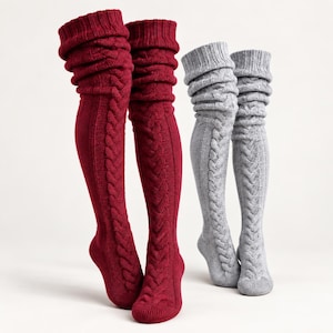 Puede incluir: Dos pares de calcetines por encima de la rodilla, un par en rojo burdeos intenso y otro en gris jaspeado claro. Cada calcetín presenta un patrón de punto de ochos vertical en la parte delantera, un puño acanalado y una textura de punto suave.