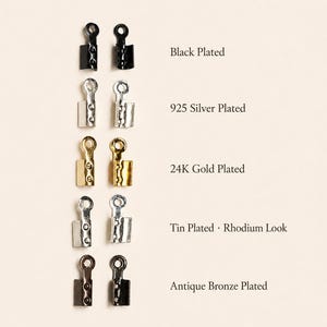 May include: Five pairs of metal ribbon crimp ends arranged vertically. The finishes include black plated, 925 silver plated, 24K gold plated, tin plated with a rhodium look, and antique bronze plated. Each piece features a loop and teeth.
