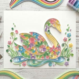 May include: A detailed paper quilling artwork depicting a swan, crafted with colourful paper strips. The swan features floral patterns in shades of pink, yellow, blue, and green. The artwork includes a water element and surrounding flowers, showcasing a detailed craft.