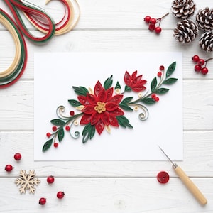 Könnte beinhalten: Ein Papier-Quilling-Kunstwerk mit einem zentralen roten Weihnachtsstern, grünen Blättern, roten Beeren und goldenen Akzenten auf einer weißen rechteckigen Karte. Das Design besteht aus kunstvoll gerollten Papierstreifen.