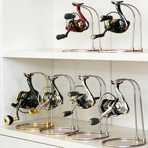 Puede incluir: Una taza de cerámica blanca con un asa negra y el texto "But First, Coffee" en negro y negrita. La taza está sobre una superficie de madera. La taza mide aproximadamente 10 cm de alto.