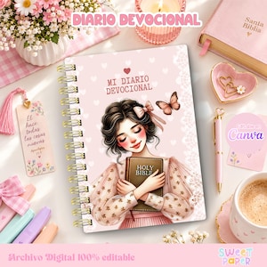 Pode incluir: Um diário devocional em espiral com capa rosa claro apresentando uma pessoa segurando uma Bíblia Sagrada, uma borboleta e padrões de corações brancos. O texto diz MI DIARIO DEVOCIONAL. Inclui um marcador de página, uma caneta e um prato em forma de coração.
