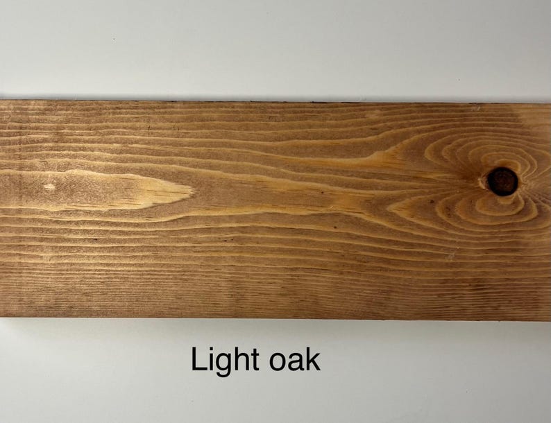 K&ouml;nnte beinhalten: Nahaufnahme einer hellen Eichenholzplanke mit sichtbarer Maserung und einem Astloch. Das Holz hat einen warmen, nat&uuml;rlichen Farbton und der Text "Light oak" wird unten angezeigt.