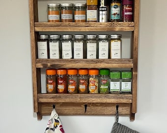 Handmade rustic wooden spice rack with an aditional set of hooks. Made with reclaimed materials with a choice of finishes
