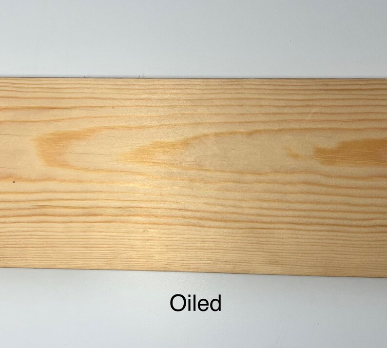 K&ouml;nnte beinhalten: Nahaufnahme einer hellen, ge&ouml;lten Holzplanke. Die Holzmaserung ist sichtbar, mit Farbvariationen von hellem Beige bis zu einem dunkleren, w&auml;rmeren Ton. Das Wort "Oiled" ist unten im Bild in Schwarz gedruckt.