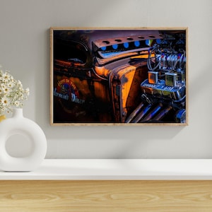 May include: Framed print featuring a close-up of a vintage car engine. The image showcases the rusted orange body of the car, with blue accents and a shiny chrome engine. The text "Home of the Vermin's Diner" is visible on the car.