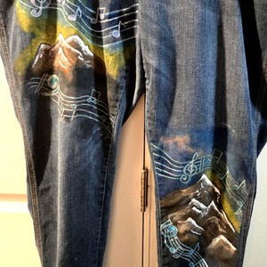 May include: A white ceramic mug with a black handle and the text "But First, Coffee" in a bold, black font. The mug is sitting on a wooden surface. The mug is approximately 4 inches tall.