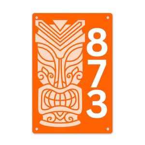 May include: Orange metal address sign featuring a tiki mask design in light orange. The number "873" is vertically displayed in white. The sign has rounded corners and pre-drilled holes for mounting.