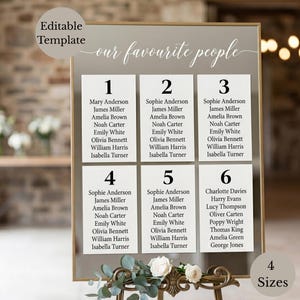 May include: A rectangular wedding seating chart sign with a gold frame, featuring the text "our favourite people" and six white columns numbered one through six, each listing names of guests. The sign is decorated with white roses and green leaves.