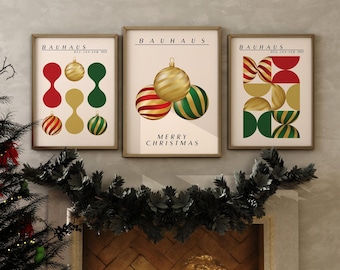 May include: Three framed wall art prints featuring Bauhaus-style geometric designs and Christmas ornaments in red, green, and gold. The central print includes the text "BAUHAUS" and "MERRY CHRISTMAS" in black lettering, while the side prints feature "BAUHAUS".
