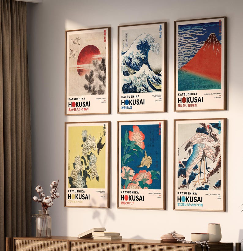 May include: A set of six framed wall art prints featuring Katsushika Hokusai artwork. Each vertical print displays a unique Japanese-inspired illustration, including a red sun, a large wave, a mountain, flowers, and birds, with bold text labels.