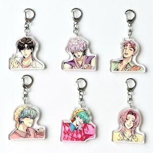 May include: Six clear acrylic keychains featuring anime-style illustrations of male characters. Each keychain has a silver-colored metal ring and chain. The characters have different hair colors and wear various outfits, including shirts and sweaters.