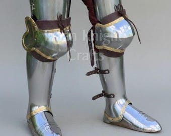 May include: Polished steel leg armor with brown leather straps and accents. The armor includes knee and ankle protection, reflecting the light. The image shows a close-up of the lower body, showcasing the craftsmanship of the medieval-style armor.