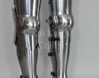 May include: A pair of polished steel leg armor, featuring articulated plates and straps. The armor is designed to protect the legs and feet. The image includes the text "Izaan Knight Crafts" and "ONLINE SOLUTION".
