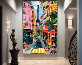 Op de afbeelding: Een kleurrijk schilderij van een Parijse straatscène met de Eiffeltoren op de achtergrond. Gebouwen zijn geschilderd in helder roze, geel en oranje, met rode luifels en bloembakken. Een zwarte lijst omringt het kunstwerk.
