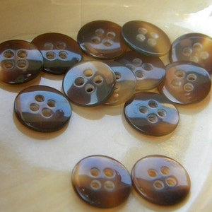 May include: A collection of brown and black four-hole buttons. The buttons are made of a shiny material and have a slightly iridescent sheen.