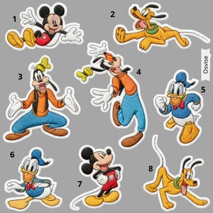 May include: A white ceramic mug with a black handle and the text "But First, Coffee" in a bold, black font. The mug is filled with a dark liquid, probably coffee, and rests on a light-coloured surface.