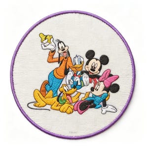 May include: Embroidered patch featuring Disney characters Mickey Mouse, Minnie Mouse, Goofy, Donald Duck, and Pluto. The patch is round with a purple border and a white background. The characters are in bright colours.