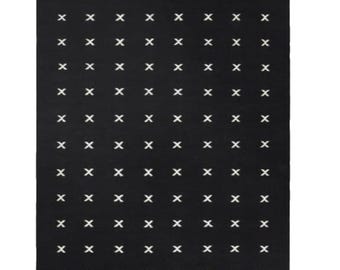 Alfombra de lana tejida a mano: diseño geométrico escandinavo en negro y crema para una decoración moderna.