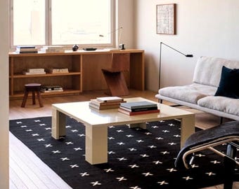 Alfombra de lana tejida a mano: diseño geométrico escandinavo en negro y crema para una decoración moderna.