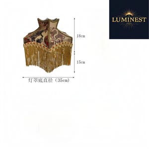 May include: A square lampshade with a floral pattern in red, black, and beige, featuring gold fringe trim. The shade measures 18 cm in height for the top section, 15 cm for the fringe, and has a base diameter of 35 cm. Includes the text LUMINEST 1065.