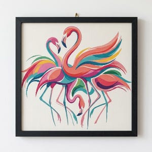 Puede incluir: Un bordado en punto de cruz con marco cuadrado que muestra tres flamencos estilizados en tonos vibrantes de rosa, naranja, amarillo, azul verdoso y azul. Las aves tienen cuellos largos y plumaje colorido sobre un fondo de tela color crema.