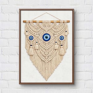 May include: A cream-colored macrame wall hanging suspended from a wooden dowel, featuring intricate knotted patterns and fringe. The design is accented with three circular blue and white evil eye charms and small matching blue beads.