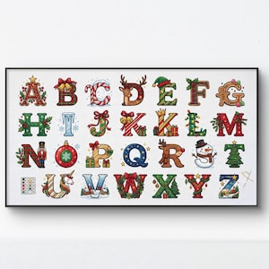 May include: A cross-stitch pattern featuring the alphabet from A to Z, where each letter is decorated with Christmas-themed elements like reindeer, snowmen, candy canes, presents, holly, and ornaments, all set against a white grid background.