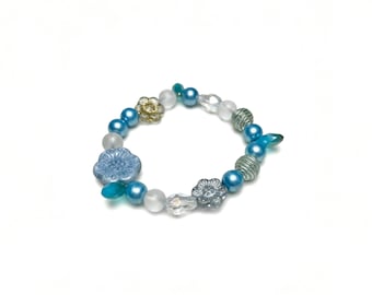 Pulsera elástica bohemia de cristal checo hecha a mano con flores y cuentas en azul agua.