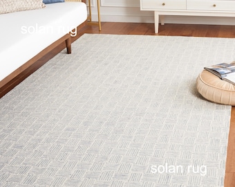 Alfombra geométrica gris y marfil, minimalista y moderna con textura, ideal para sala de estar y dormitorio.