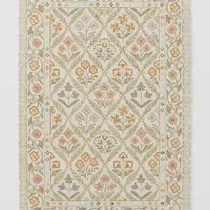 Puede incluir: Alfombra rectangular con estampado floral sobre fondo crema. El diseño presenta un patrón de diamantes repetido con flores rosas, naranjas y azules. El borde tiene un diseño floral en colores similares. Adecuado para la decoración del hogar.