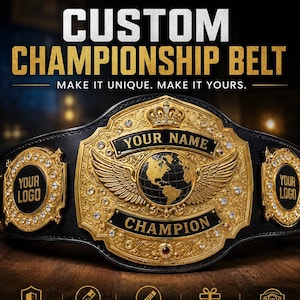 May include: A black leather championship belt featuring a large gold center plate with a globe, wings, and crown motif, surrounded by clear crystals. The belt includes customizable side plates, gold studs on the strap, and text reading CUSTOM CHAMPIONSHIP BELT.