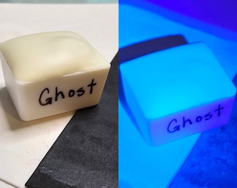 May include: A white cube with the word "Ghost" written on it. The cube glows bright blue under a black light.