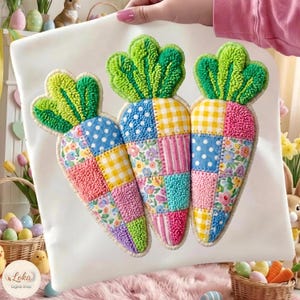 May include: A white fabric featuring three carrot appliqués. Each carrot has a patchwork design with blue polka dots, yellow gingham, floral, and pink striped patterns. The carrot tops are green and textured.