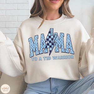 Retro Diabetes Awareness PNG design featuring “Mama to a T1D Warrior” text with blue ribbon, vintage style Type 1 Diabetes mom graphic for November awareness and support