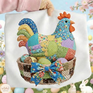 Könnte beinhalten: Ein dekoratives Kissen zum Thema Ostern mit einer Patchwork-Henne mit blauem Blumenmuster, einem roten Kamm und einem Korb mit bunten Eiern. Der Korb hat eine blaue Blumenschleife.