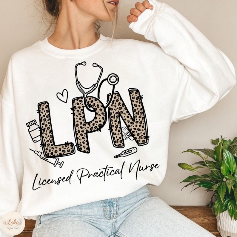 May include: White sweatshirt with the letters "LPN" in a leopard print design, a stethoscope, a heart, and medical-related graphics. The words "Licensed Practical Nurse" are written below the design in a cursive font. The sweatshirt is a casual style.
