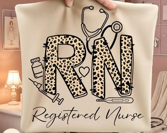 May include: A beige tote bag featuring the letters "RN" in a leopard print design, with a stethoscope, heart, and medical icons. The words "Registered Nurse" are written in a script font below the letters.