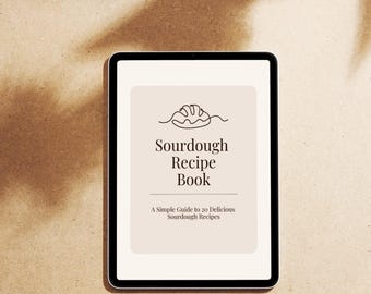 Peut inclure: Une tablette numérique affichant la couverture d'un livre de recettes. La couverture est beige avec le titre "Sourdough Recipe Book" en police serif, et un dessin au trait d'un pain. Le sous-titre se lit "A Simple Guide to 20 Delicious Sourdough Recipes."
