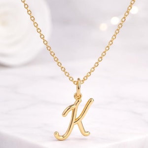 Collana con iniziale in corsivo in argento sterling, ciondolo a forma di lettera elegante.