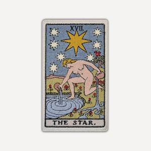 Può includere: Una toppa ricamata rettangolare che raffigura la carta dei tarocchi La Stella. Presenta una figura inginocchiata vicino a una pozza, che versa acqua da due brocche sotto una grande stella gialla e sette stelle bianche più piccole. Testo XVII e THE STAR.