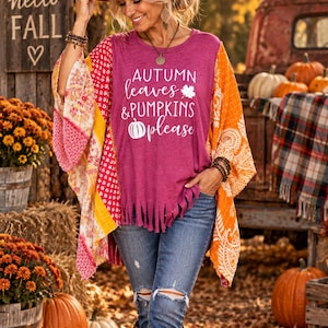 May include: A magenta short-sleeved top with fringe at the hem, featuring the white text "AUTUMN leaves & PUMPKINS please" with a leaf and pumpkin icon. The top has attached multicolored patterned kimono-style sleeves in shades of orange and pink.
