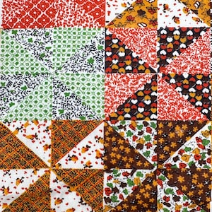 May include: A patchwork quilt featuring a repeating pinwheel block pattern. The fabric squares display various printed designs in shades of red, orange, yellow, green, brown, and white, including floral, geometric, and heart-shaped motifs.