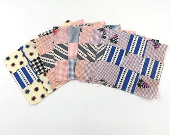 Può includere: Sei quadrati di patchwork fatti a mano in vari motivi e colori, tra cui rosa, blu, bianco e nero. I quadrati sono realizzati in tessuto di cotone e presentano disegni floreali, a quadri e a righe.