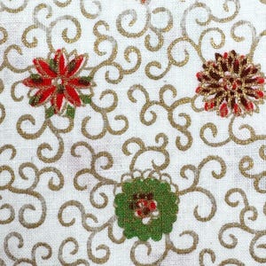 May include: White fabric with a repeating pattern of gold swirls and floral designs. The flowers are red, green, and gold, creating a festive and decorative look. The fabric has a textured appearance.
